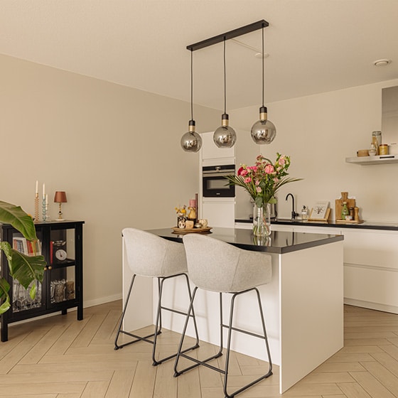 Lichte keuken met een kookeiland en barstoelen