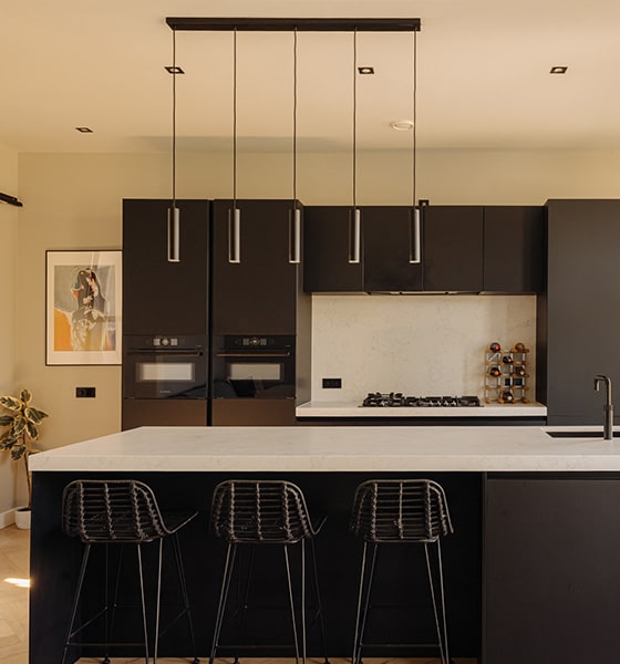 Foto van een luxe keuken met donkere keukenkasten en een riant kookeiland